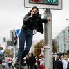 Photo reporter Darya Burakina stands on a fence holding a camera, photographing a protest column in Minsk, Belarus, on October 25, 2020.