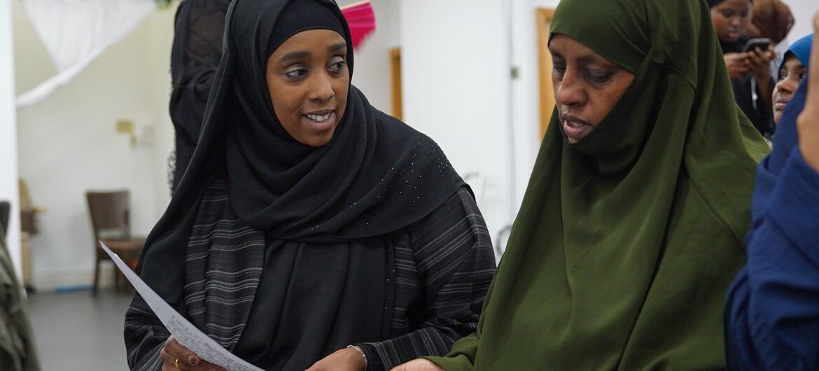 Safia Jama, originally from Somalia, engages in community care with another woman in London, reflecting her lifelong commitment to supporting women and communities in the UK.