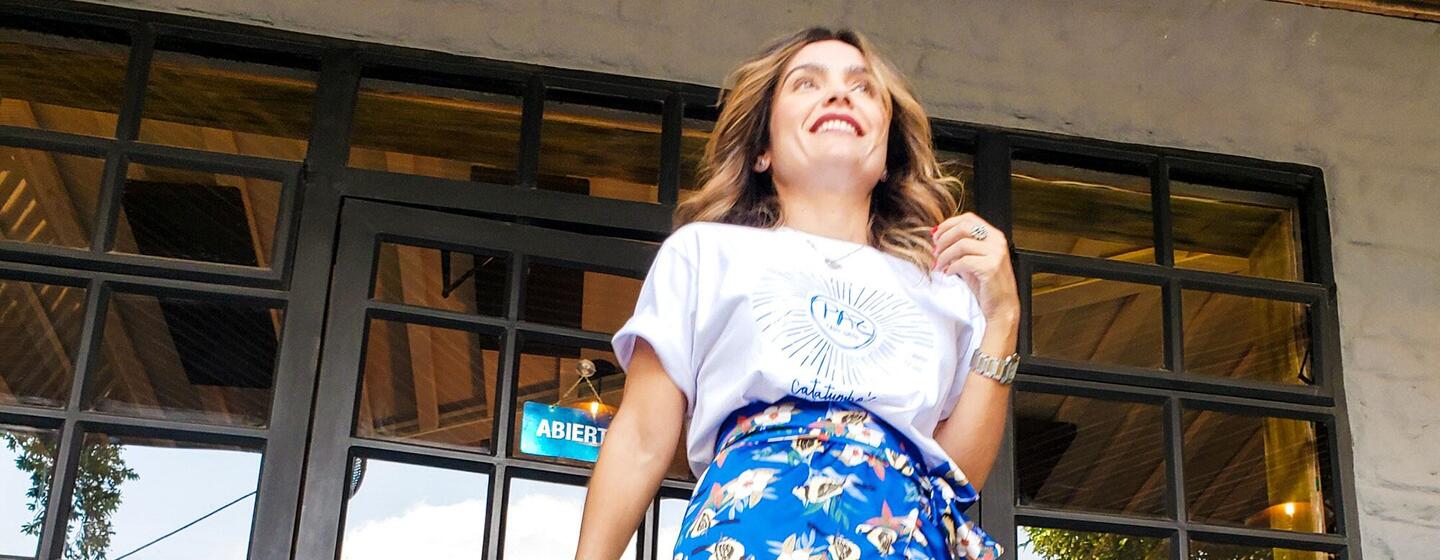 Lina Garces, a fashion expert and peace agreement survivor, smiles while modeling colorful floral skirts from the Ixora brand she co-created with other women.