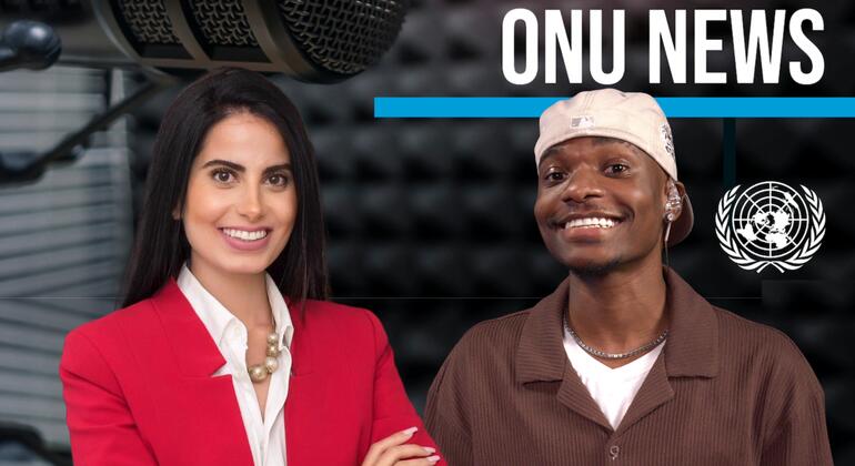 Uma apresentadora e um convidado posam em um estúdio de podcast com um grande microfone e o emblema da ONU visíveis.