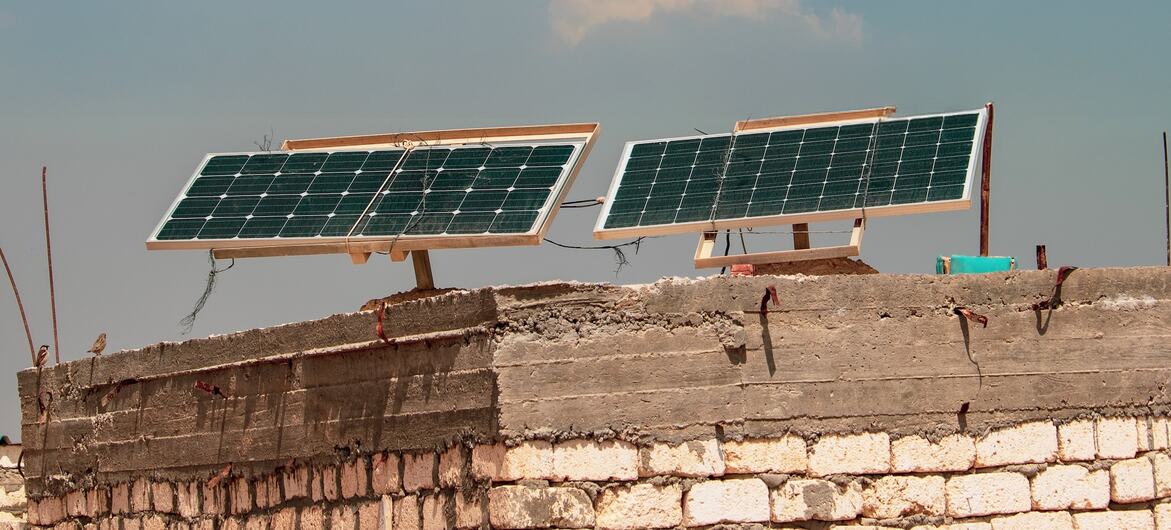 Две солнечные панели установлены на кирпичной крыше под частично облачным небом в рамках инициативы ПРООН "Индия в области солнечной подготовки".