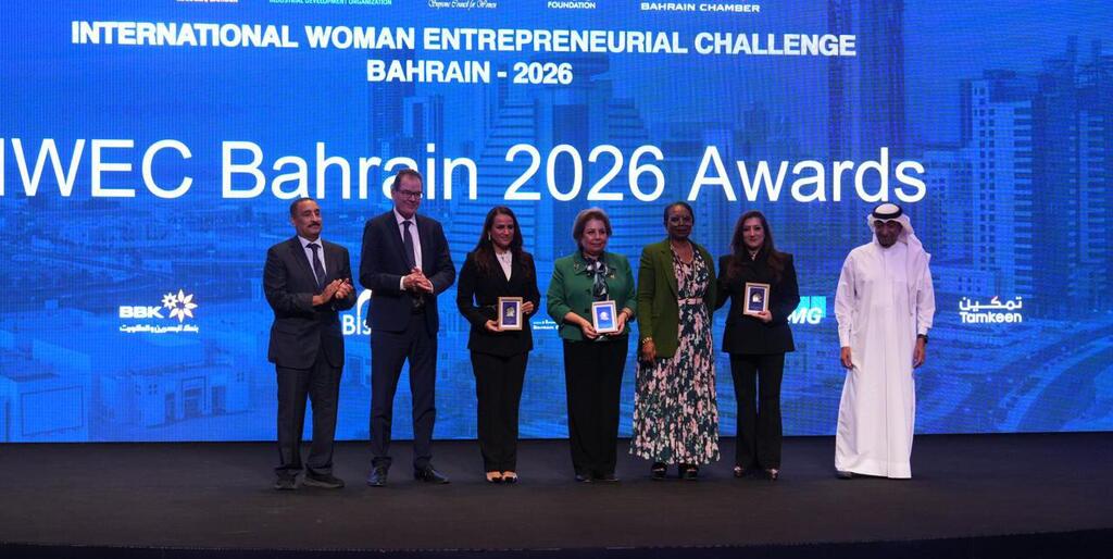 Awards ceremony for the International Woman Entrepreneurial Challenge Bahrain 2026, featuring awardees holding framed certificates on stage.