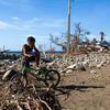 Un niño se sienta en una bicicleta verde en medio de escombros y escombros en Guamá, Santiago de Cuba, después de que el huracán Melissa causara grandes destrucciones.