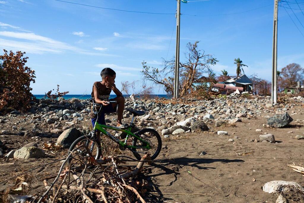 L'ouragan Melissa a frappé Cuba à la fin du mois d'octobre 2025, provoquant une dévastation massive à travers la nation insulaire. Un jeune garçon est assis sur un vélo vert au milieu des décombres et des débris à Guamá, à Santiago de Cuba, après que l'ouragan Melissa ait causé des dégâts considérables.