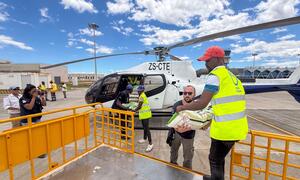 Staff from UNOCHA and partners load food aid into a helicopter at an airport in Xai Xai, Mozambique, to deliver assistance to flood victims.