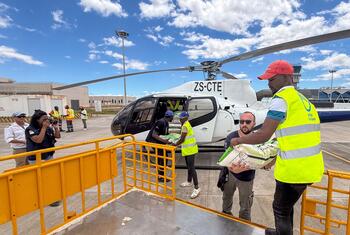 Le personnel de l'UNOCHA et ses partenaires chargent l'aide alimentaire dans un hélicoptère à un aéroport de Xai Xai, au Mozambique, pour apporter de l'aide aux victimes des inondations.