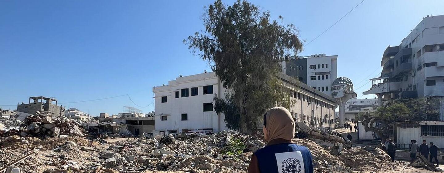 Un travailleur du PNUD se tient devant les ruines de l'hôpital Al-Shifa à Gaza, surveillant les dommages causés à l'infrastructure des soins de santé.