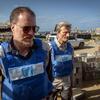 Shaun Hughes, directeur pays du PAM à Gaza, vêtu d'un gilet bleu de l'ONU et de lunettes de soleil, se promène dans un site de destruction et de décombres.