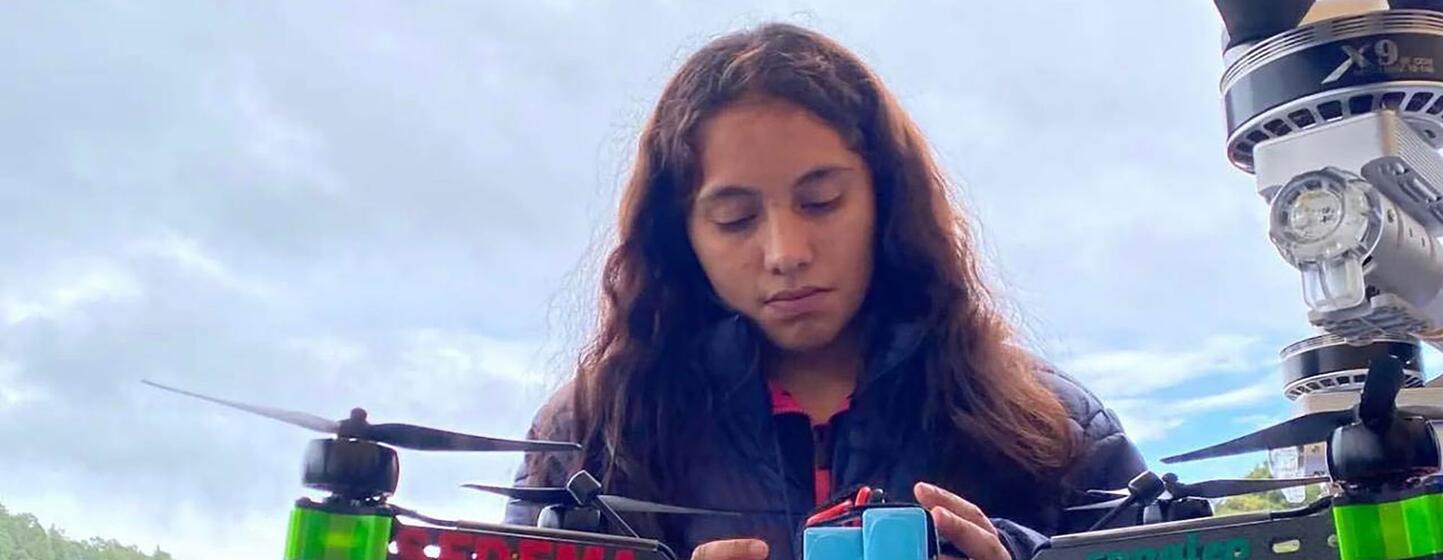 Valeria Palacios, una joven mujer ingeniera en México, está realizando una prueba de drones en un campo al aire libre.