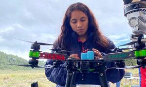 Valeria Palacios, una joven mujer ingeniera en México, está realizando una prueba de drones en un campo al aire libre.
