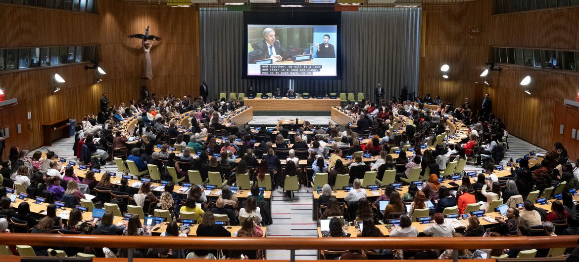 Wide view of a townhall meeting with the UN Secretary-General and civil society participants at the 70th session of the Commission on the Status of Women (CSW). A large audience is seated in a modern conference hall, with a large screen displaying the event.