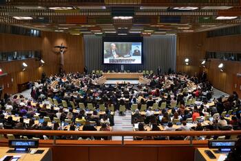 Vue large d'une réunion à l'hôtel de ville avec le Secrétaire général des Nations Unies et les participants de la société civile lors de la 70e session de la Commission sur le statut des femmes (CSW). Un grand public est assis dans une salle de conférence moderne, avec un grand écran affichant l'événement.