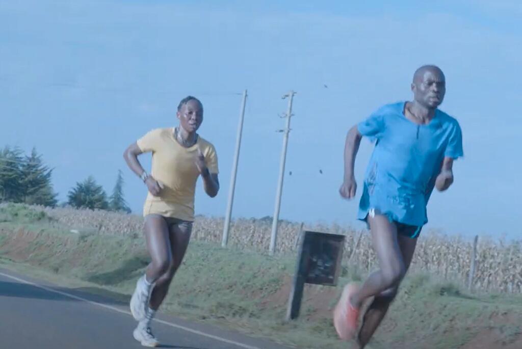 Mwanamume na mwanamke wanakimbia kwenye barabara ya lami kupitia eneo la vijijini nchini Kenya, na mashamba ya mahindi kwenye mandhari ya nyuma.