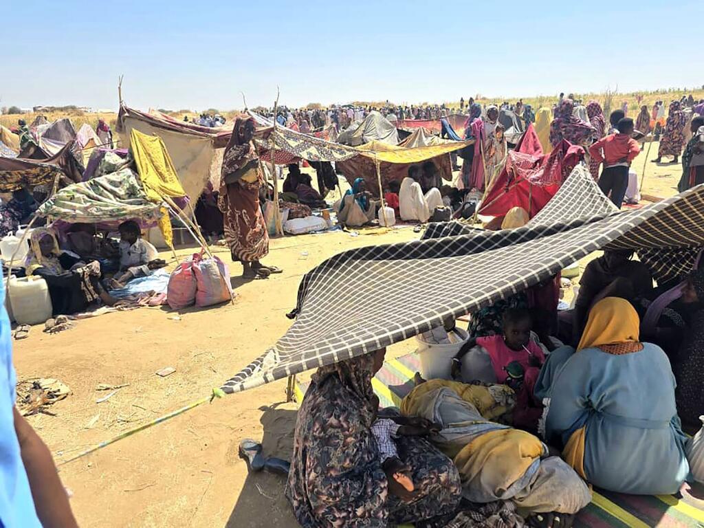 Des personnes cherchant refuge sur le site de déplacement de Tawila au Soudan. Des femmes et des enfants sont assis sous des tentes de fortune dans un paysage sec et poussiéreux alors que le HCR et ses partenaires fournissent une aide vitale, notamment un abri, des biens de première nécessité et un soutien psychosocial aux personnes qui ont fui El Fasher.