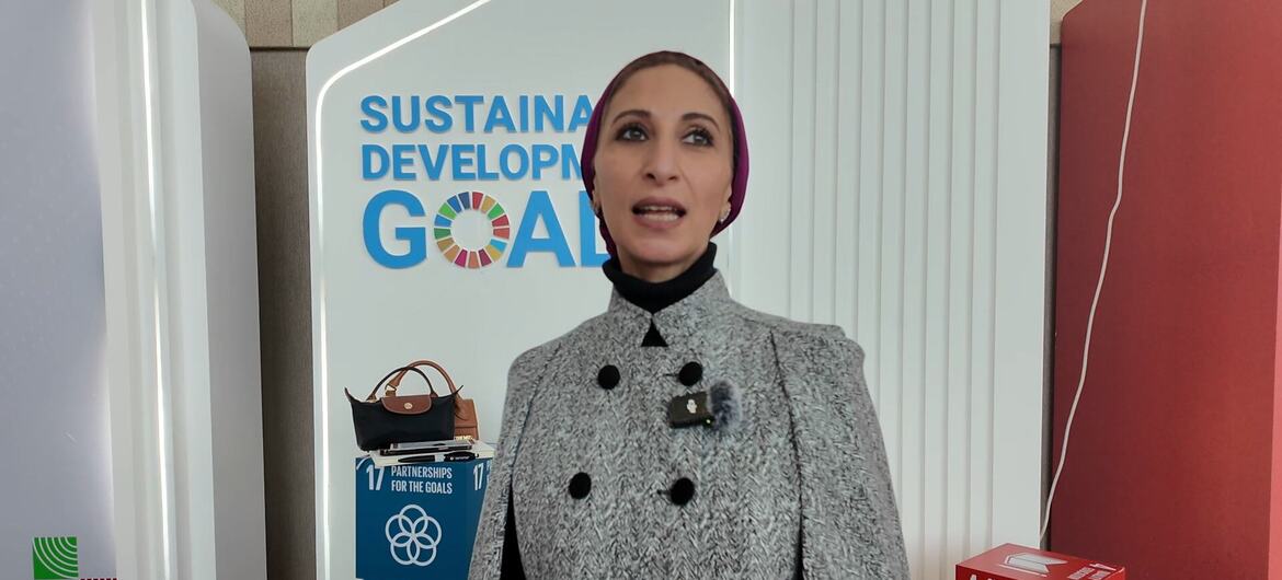 Dina Najar, journaliste de l'ONU, se tient devant un écran présentant les objectifs de développement durable, en particulier l'ODD 4 (l'éducation de qualité), l'ODD 16 (la paix, la justice et des institutions fortes) et l'ODD 17 (les partenariats pour les objectifs), lors de l'événement WEIF2026 à Manama, Bahreïn.