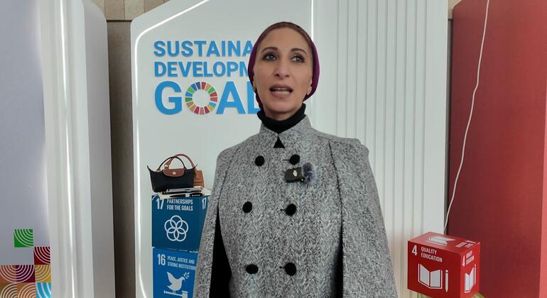 دينا نجار، مراسلة الأمم المتحدة للأخبار، تقف أمام خلفية تعرض أهداف التنمية المستدامة، وتحديدا SDG 4 (التعليم الجيد) ، SDG 16 (السلام والعدالة والمؤسسات القوية) ، وSDG 17 (الشراكات من أجل الأهداف) ، في حدث WEIF2026 في ماناما، البحرين.