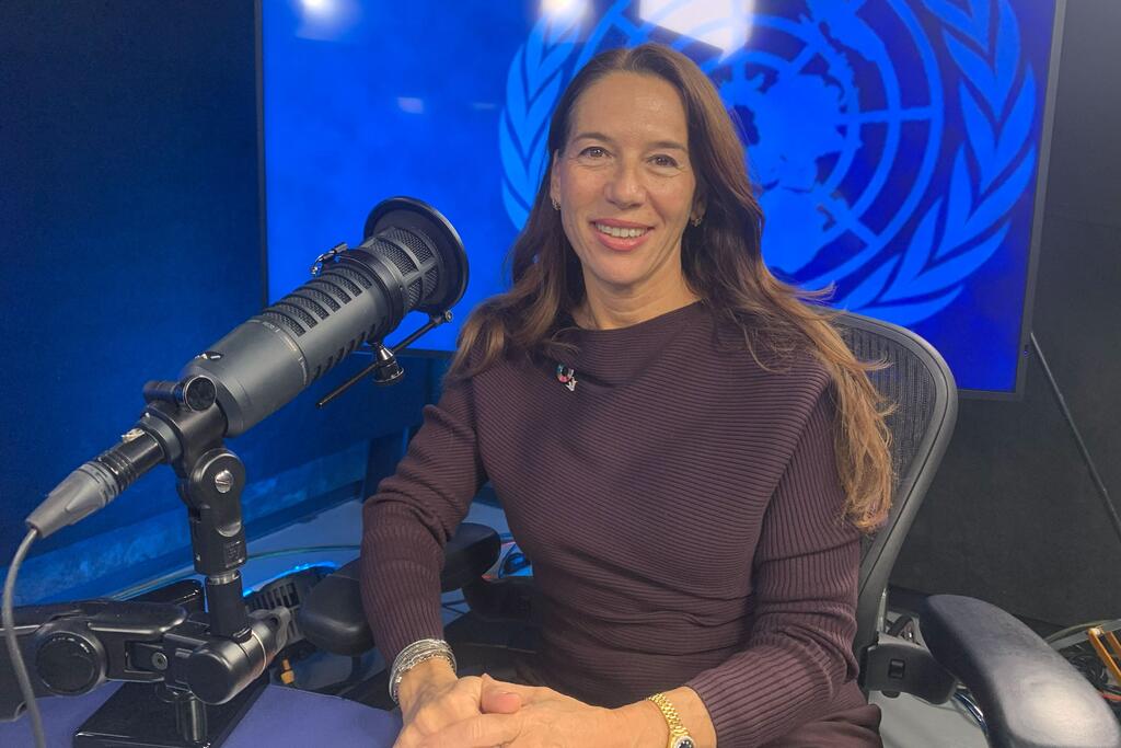 Vanessa Frazier, mwakilishi maalum wa Umoja wa Mataifa kwa watoto na migogoro ya silaha, ameketi katika studio na nembo ya Umoja wa Mataifa nyuma, akitabasamu wakati wa mahojiano na UN News.