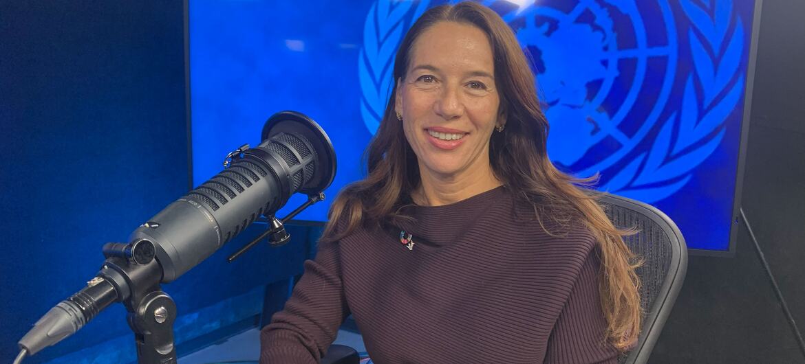 Vanessa Frazier, UN Special Representative for Children and Armed Conflict, seated in a studio with a UN emblem in the background, smiling during an interview for UN News.