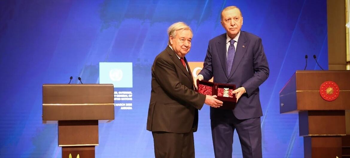 UN Secretary-General António Guterres receives the Atatürk International Peace Prize from Turkish President Recep Tayyip Erdoğan on a stage.