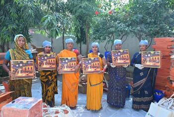 महिला उत्पादक सावधानी से पैक किए गए फलों के हैम्पर दिखा रही हैं, जो उनके गाँव से बहुत दूर बाज़ारों तक पहुँचेंगे.