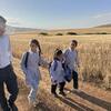 El portavoz de UNICEF, James Elder, camina con un grupo de escolares palestinos por un campo de trigo dorado en Cisjordania.