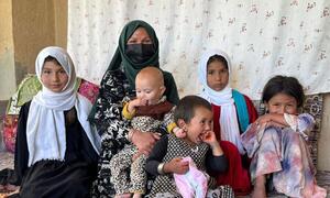 افغان خاتون راقیبہ احمدی اپنے چھ بچوں کے ساتھ افغانستان کے شہر فیض آباد میں بیٹھی ہیں، جو غذائی قلت کے بحران کی عکاسی کرتی ہیں۔