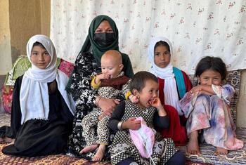 Afghan woman Raqiba Ahmadi sits with her six children in Faizabad, Afghanistan, highlighting the crisis of malnutrition.