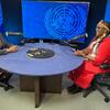 Wanawake wawili wameketi kwenye meza ya mviringo wakiwa na maikrofoni katika studio, na nembo za Umoja wa Mataifa kwenye skrini nyuma yao.