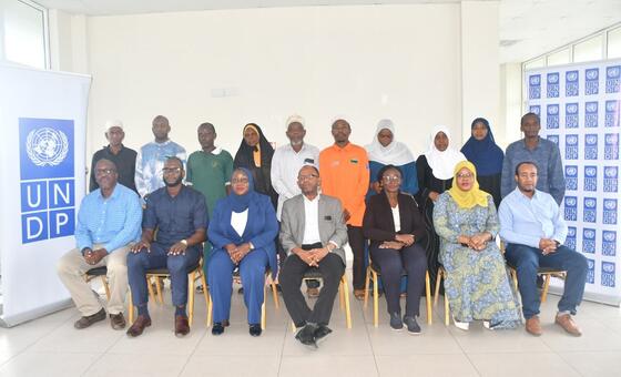Kikundi cha wanaume na wanawake wanapiga picha katika tukio la UNDP huko Zanzibar, Tanzania.