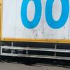 Боковой вид жёлтого грузовика ВПП с синими надписями на белом грузовом контейнере.