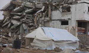 A UNICEF tent stands in front of a destroyed building in Gaza, highlighting the humanitarian crisis and emergency aid efforts in the region.