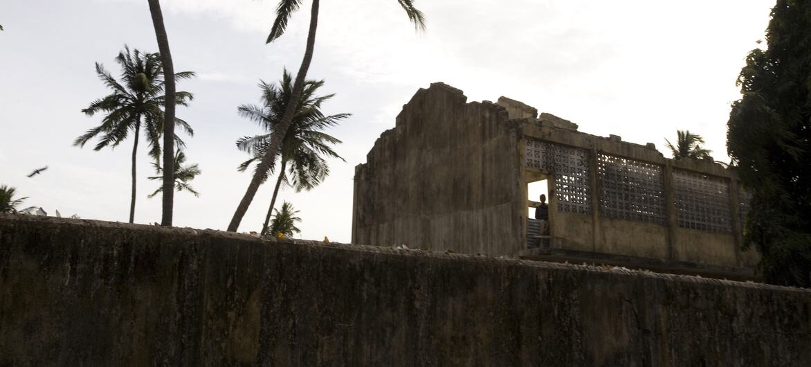 A 2007 photograph showing a long shot of a man standing in a damaged, roofless structure in Jaffna District, Northern Province, Sri Lanka, amid conflict and displacement following the 2006 ceasefire collapse.