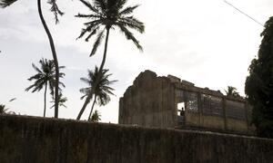 A 2007 photograph showing a long shot of a man standing in a damaged, roofless structure in Jaffna District, Northern Province, Sri Lanka, amid conflict and displacement following the 2006 ceasefire collapse.