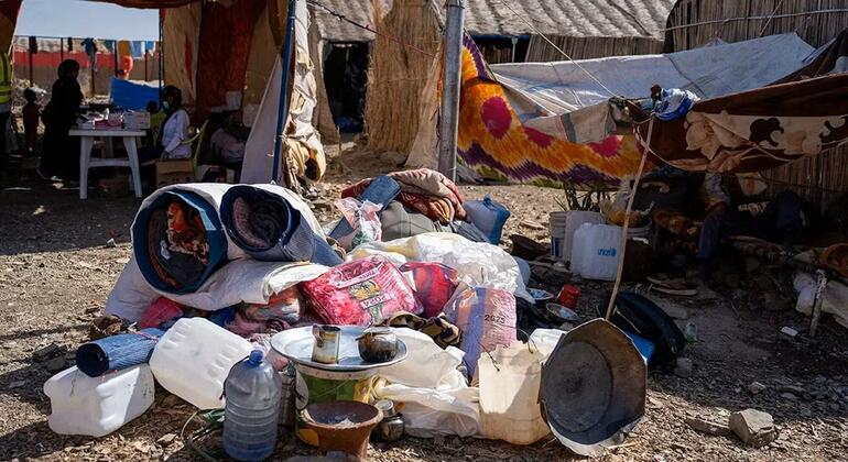 Picha ya hali ya maisha katika kambi ya wakimbizi ya Abu Al Naja nchini Sudan, ikionyesha rundo la misaada ya kibinadamu ikiwa ni pamoja na vifaa vya maji, blanketi, na mifuko ya chakula mbele ya makazi ya muda.