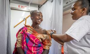 Mwanamke mmoja nchini Kenya anapokea chanjo kutoka kwa mfanyakazi wa afya, akikazia mipango ya Shirika la Afya Ulimwenguni kwa ajili ya afya ya uzazi.