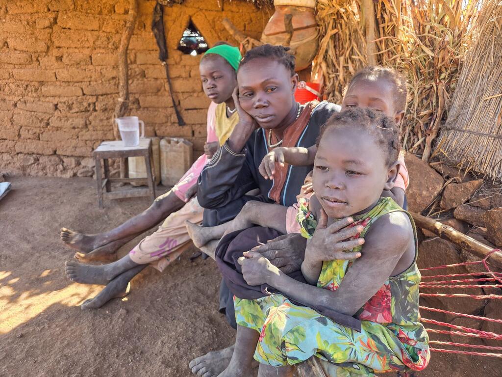 Une femme et ses enfants sont assis ensemble dans un refuge de fortune à Kordofan du Sud, au Soudan, déplacés par le conflit en cours et dans le besoin d'une aide humanitaire.