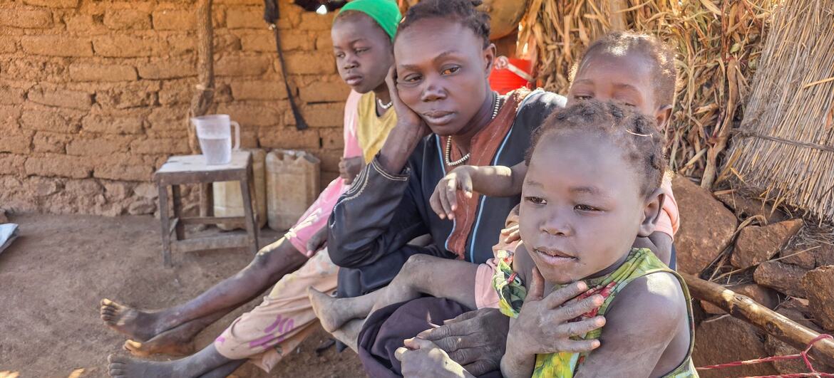 امرأة وأطفالها يجلسون معاً في ملجأ مؤقت في جنوب كردفان، السودان، نزحوا بسبب النزاع المستمر ويحتاجون إلى المساعدات الإنسانية.