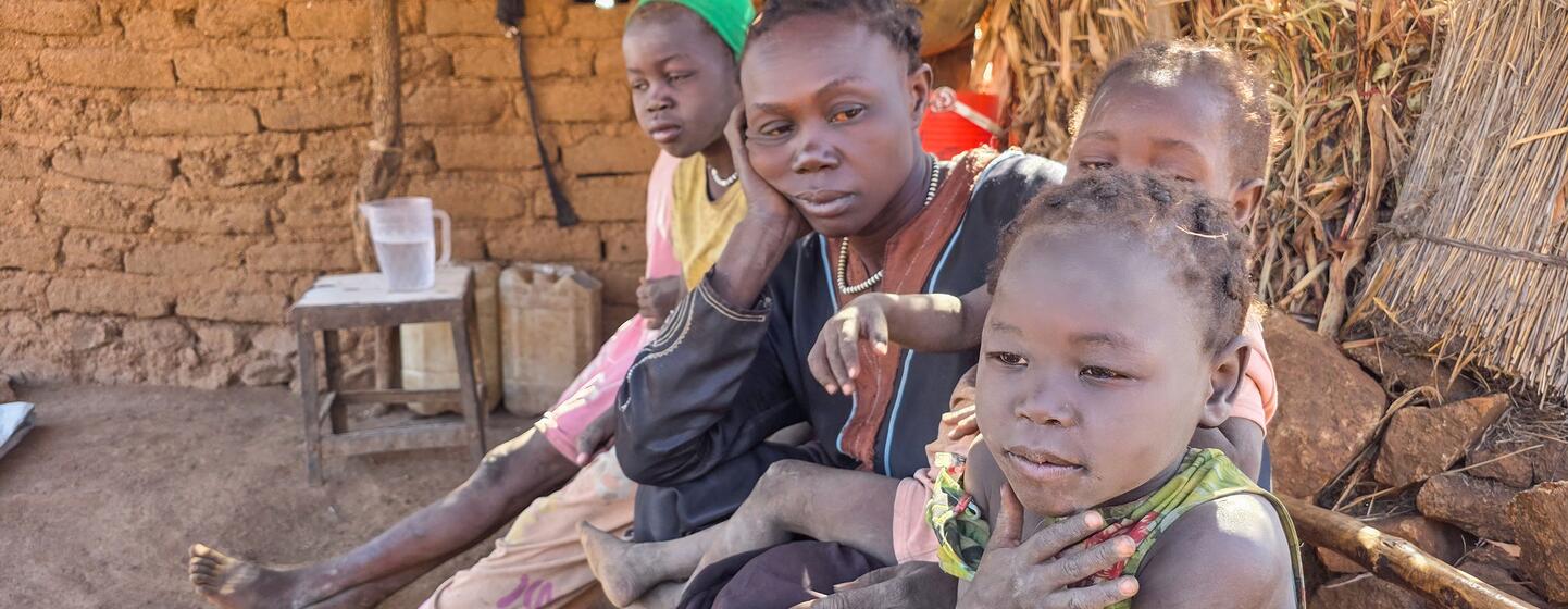 Une femme et ses enfants sont assis ensemble dans un refuge de fortune à Kordofan du Sud, au Soudan, déplacés par le conflit en cours et dans le besoin d'une aide humanitaire.