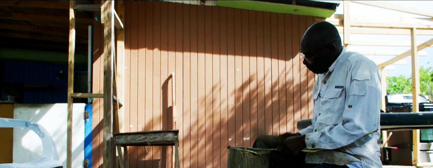 Un artesano local de las Bahamas pela la corteza de la cascara para extraer aceite que se utiliza en todo el mundo para hacer cócteles.