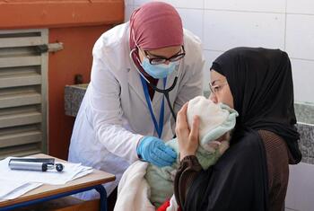 मौसावत संगठन की एक महिला चिकित्सा कार्यकर्ता लेबनान में एक क्लिनिक में अपनी मां द्वारा रखे गए एक नवजात शिशु की जांच करती है, जो संघर्ष से विस्थापित परिवारों को स्वास्थ्य सेवा प्रदान करती है।