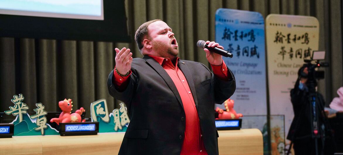 艾伦在中国语言日活动上登台演唱，手持麦克风。