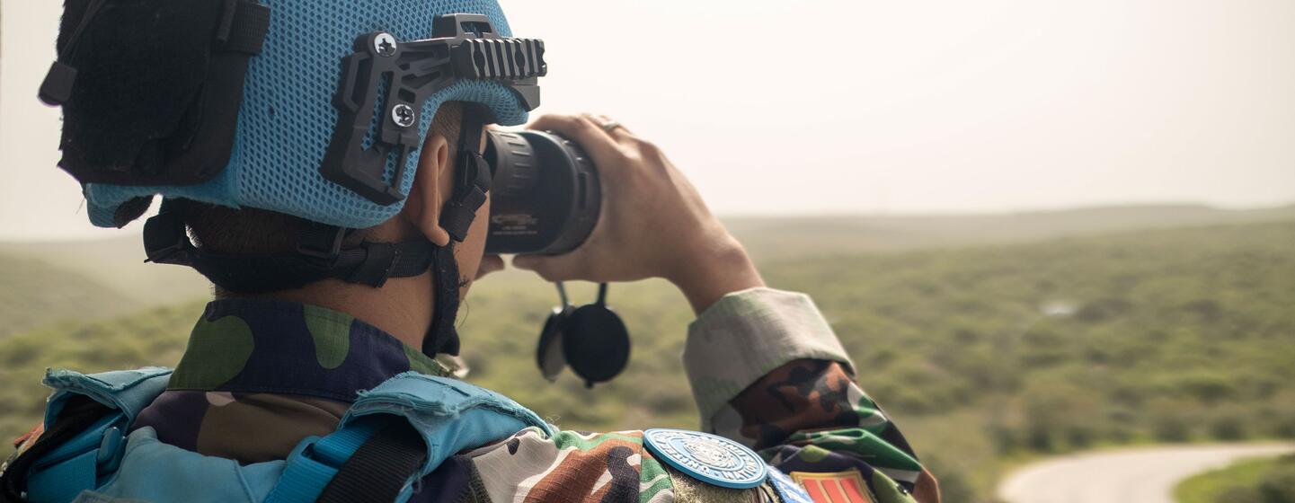 Un casque bleu indonésien de la FINUL utilise des jumelles pour observer la zone de Green Hill près du quartier général de Naqoura au Liban.