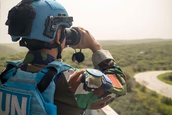 A UNIFIL Indonesian peacekeeper uses binoculars to observe the Green Hill area near Naqoura headquarters in Lebanon.