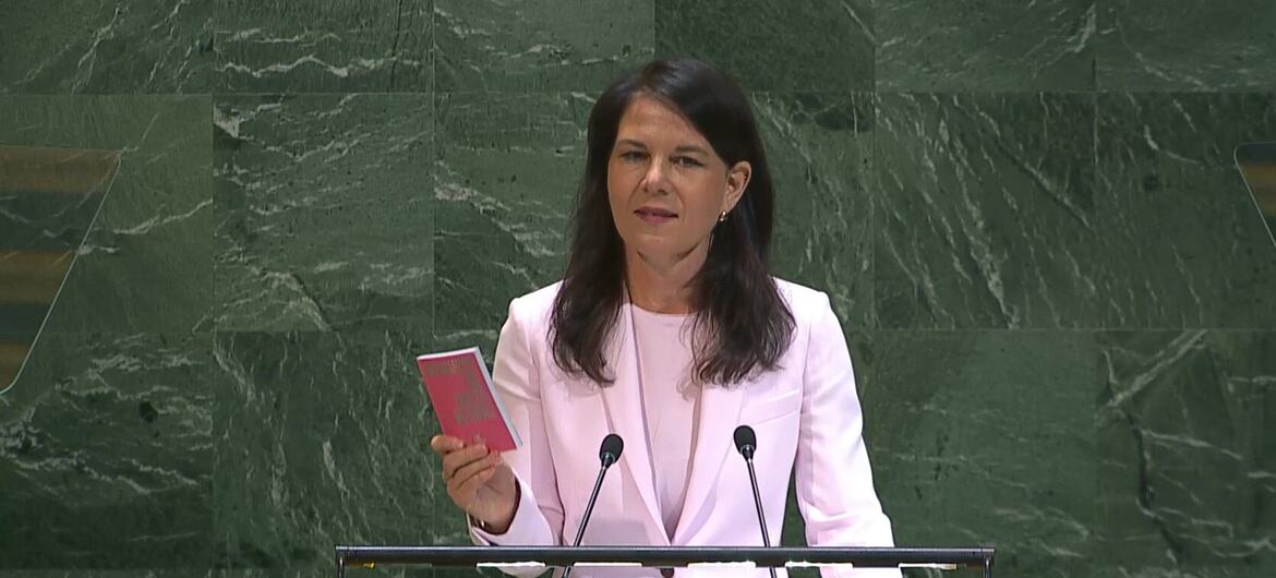 Annalena Baerbock, President of the 80th Session of the United Nations General Assembly, speaking at the podium of the General Assembly holding a pink colored copy of the Charter of the United Nations.