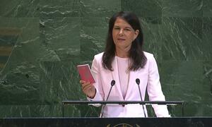 Annalena Baerbock, President of the 80th Session of the United Nations General Assembly, speaking at the podium of the General Assembly holding a pink colored copy of the Charter of the United Nations.