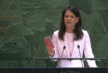 Annalena Baerbock, President of the 80th Session of the United Nations General Assembly, speaking at the podium of the General Assembly holding a pink colored copy of the Charter of the United Nations.