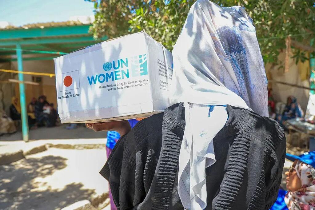 Mwanamke nchini Sudan akiwa na sanduku la misaada la UN Women kichwani mwake, sehemu ya misaada ya kibinadamu kwa wanawake na wasichana walioathiriwa na mgogoro.