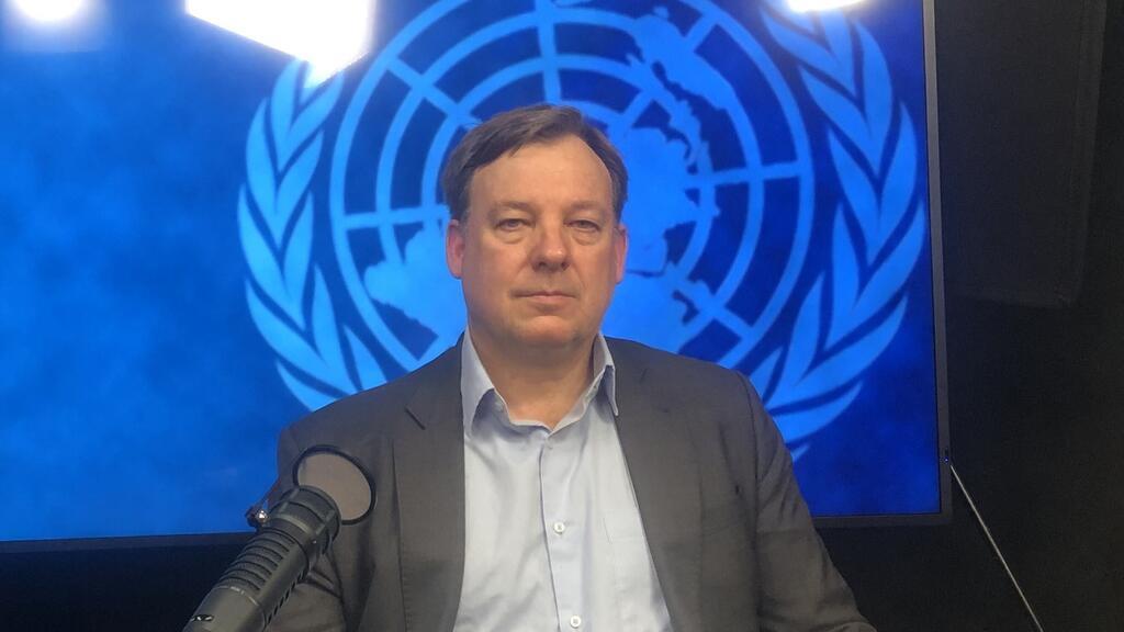 Michael Herrmann, UNFPA representative, speaking into a microphone in front of a UNFPA logo.