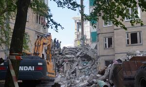 Rescue workers and an excavator at a damaged residential building in Kyiv following a Russian missile and drone attack.