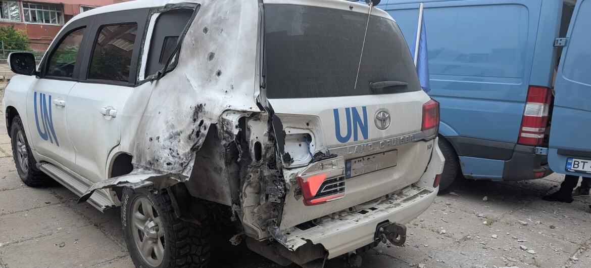 A damaged white United Nations Toyota Land Cruiser with severe rear and side damage from a drone strike in Kherson, Ukraine.